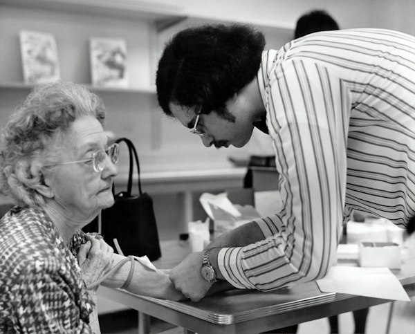 A caregiver attentively assisting an older woman